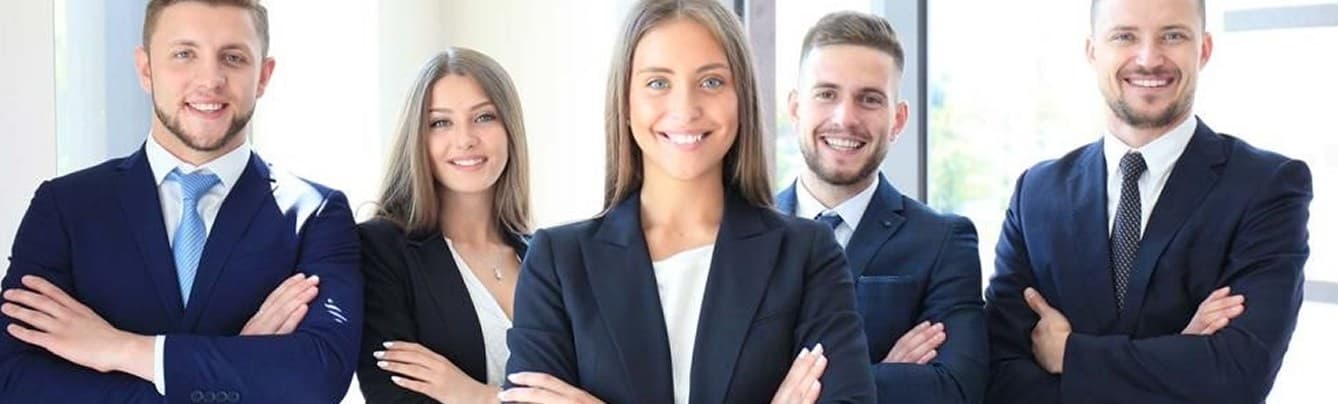 Team of five professionals standing with arms crossed